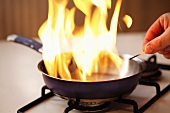 Flambéing (lighting alcohol in frying pan)