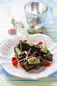 Stuffed vine leaves with tomatoes on cocktail sticks