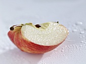 Wedge of apple with drops of water