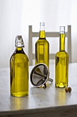Three bottles of olive oil with funnel