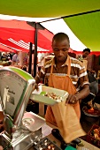 Verkäufer wiegt Pilze auf einem Markt ab (Südafrika)