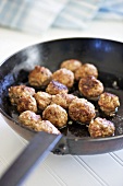 Fried meatballs in frying pan