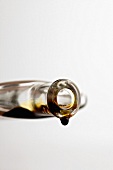 Balsamicoessig tropft aus Glasflasche