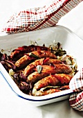 Baked sausages with bacon and onions