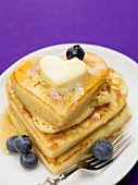 Heart-shaped pancakes with maple syrup, blueberries and butter
