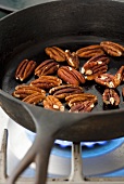 Toasted pecan nuts in frying pan
