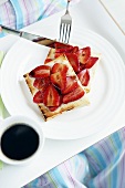 Person eating strawberries on toast with balsamic vinegar