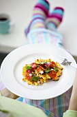 Person holding plate of corn cakes and salsa