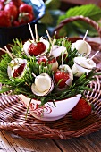 Strawberries dipped in white chocolate on cocktail sticks