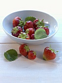 Strawberries in and in front of a bowl