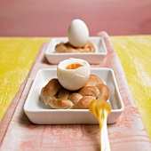 Geöffnetes Frühstücksei mit einem selbstgebackenen Eierbecher