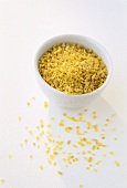 Bulgur wheat in and in front of a small bowl