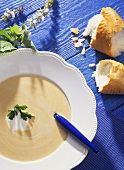 Creamed vegetable soup with blob of cream and baguette