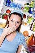 Young woman shocked at contents of fridge