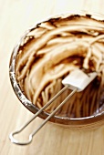 Remains of chocolate cake mixture in bowl with spatula