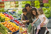 Familie am Gemüsestand im Supermarkt