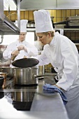 Female chef checking the contents of a pan