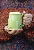 Hands holding a mug of tea