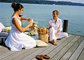 Two women picnicking on a landing stage
