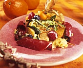 Gemischter Blattsalat mit Früchten und rohem Schinken