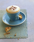Cappuccino in blue cup & saucer with cantucci (almond biscuits)