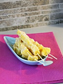 Pineapple skewers with grated coconut