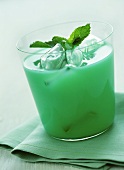 Green cocktail with ice cubes and mint leaves