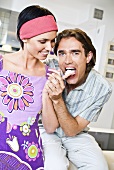 Man licking whipped cream from a woman's finger