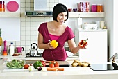 Woman with fresh vegetables in kitchen