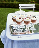 Chocolate mousse with cream and flowers served in glasses