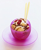 Ice cream with nuts, caramel sauce, whipped cream & raspberries