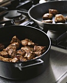 Browning pork in a frying pan
