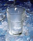 Mineralwasser in ein Glas eingiessen