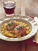 Chicken thighs wrapped in bacon on saffron rice