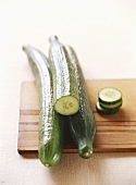 Three cucumbers on a wooden board