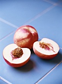 Two white nectarines, halved and whole