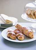 Small plaited yeast buns with strawberry icing