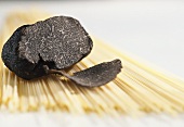 Black truffle on uncooked spaghetti