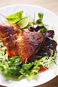 Fried salmon steak on salad leaves