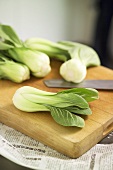 Several pak choi on a wooden board