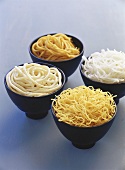 Four bowls of different noodles