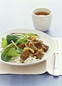 Pan-cooked beef with rice and salad leaves