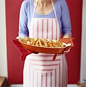 Woman holding dish of taco chicken bake