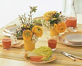 Laid table with posies of ranunculus & horned violets