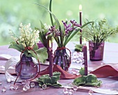 Posies of lilies-of-the-valley & irises & candles on table