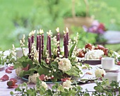 Flower wreath with candles on table laid for coffee