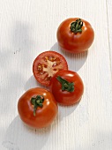 Two whole and one halved tomato