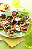 Mini-Pizzen mit Oliven, Mozzarella und Schinken
