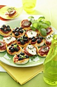 Mini-pizzas with olives, mozzarella and ham