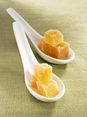 Candied ginger cubes on two spoons